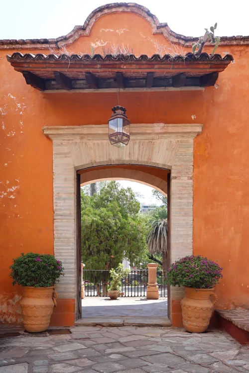 Arco de cantera de una casona que enmarca un jardín interior