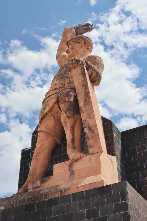 Monumento al Pípila con el brazo en alto contra el cielo