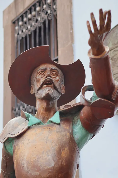 Escultura de Don Quijote en bronce con el brazo alzado